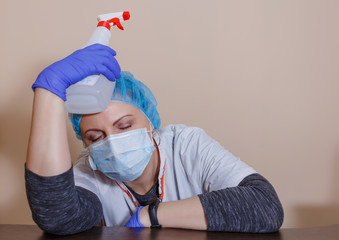 A female doctor in a sterile mask and uniform on a break after prevention during the covid-19...