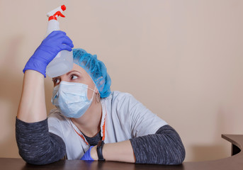 A female doctor in a sterile mask and uniform on a break after prevention during the covid-19...