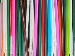 Many used plastic straws are stacked on a wooden floor. Many people use straws everyday and throw them in the trash. Take a long time to decompose these garbage Concept of environmental stewardship
