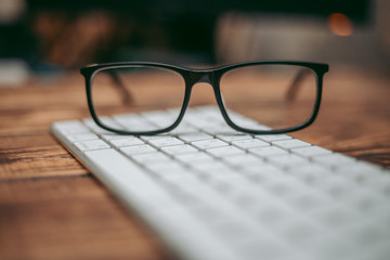 Glasses for sight and vision correction and protection from computer on the wooden table on the keyboard