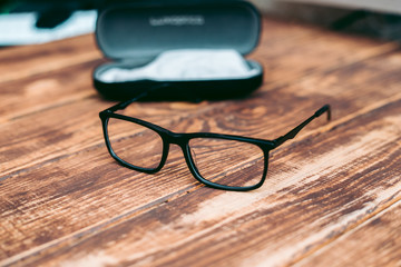 Glasses for sight and vision correction and protection from computer with ptotection case on the wooden table