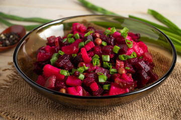 Vinaigrette on a wooden background. Russian vegetable salad with beets in a bowl.