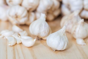 Closeup of Garlic bulb on wooden table with garlics blur background.