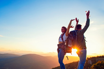 Couple on Top of a Mountain Shaking Raised Hands
