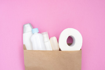 Food donation for the needy on a pink background top view. White toilet paper and hygiene products