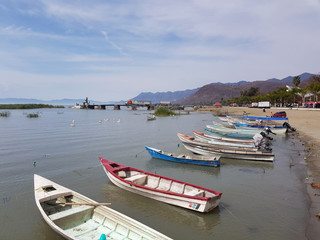 Fototapeta na wymiar Several small motorboats on the shore of Lake Chapala