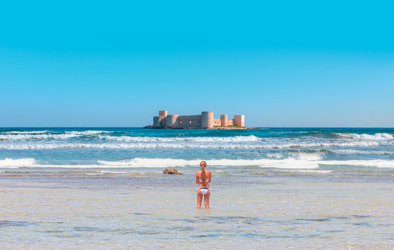 Attractive blonde woman in white bikini taking a picture of herself - The maiden's castle (Kiz Kalesi) - Mersin, Turkey 