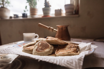 Fototapeta na wymiar freshly baked pancakes in plate on table. Tasty morning breakfast with hot flapjacks and coffee. homemade delicious fried pancakes. Selective focus