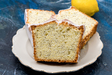 Tarta de limón con semillas de amapola y azúcar glaseada, en plato antiguo.