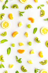 Colorful fruit pattern with citrus and kiwi slices - fresh summer fruits - on white background top-down
