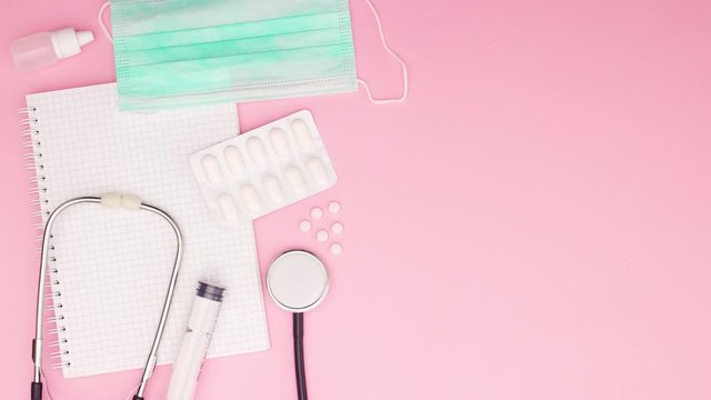 Medical instruments and equipment appear on left side of pink background - Stop motion