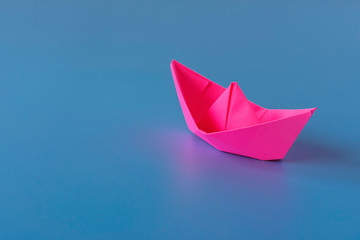 Paper boat on a blue background. Columbus Day.