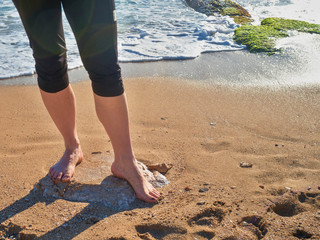 Single woman legs or foot walking at the beach