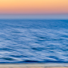 Fototapeta na wymiar textured sunset over the sea with orange sky. blurred motion - Abstract