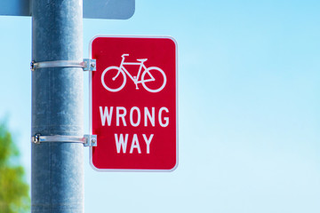 Red bicycle wrong way Sign on street pole