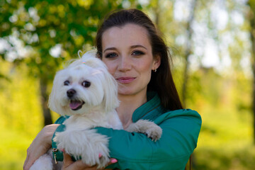 Young girl with her dog. Puppy white dog is running with it's owner. Concept about friendship, animal and freedom.