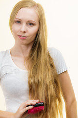 Fototapeta premium Blonde girl brushing her long hair