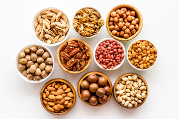 Set of macadamia, hazelnut, walnut, almond, pistachio, pecans nuts on white background top-down...