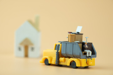 Miniature businessman sit on pickup truck with office table