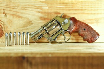 Revolver gun 38 mm size on wood background.