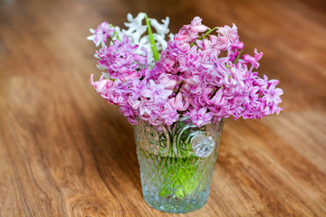 Hyacinth Flowers in a Glass Vintage Vase on a Wooden Background