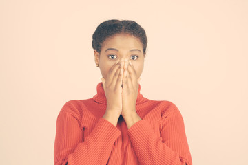 Surprised young woman covering mouth. Amazed lady looking at camera. Surprising concept