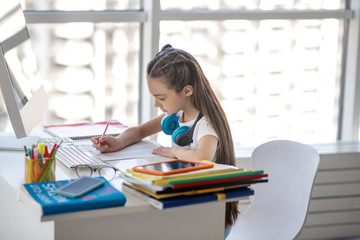 Long-haired girl in white tshirt looking busy