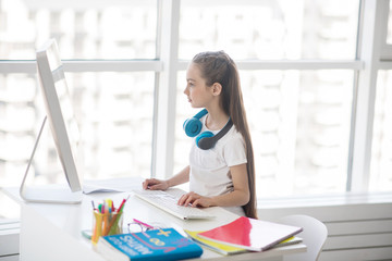 Long-haired girl in white tshirt studying at home