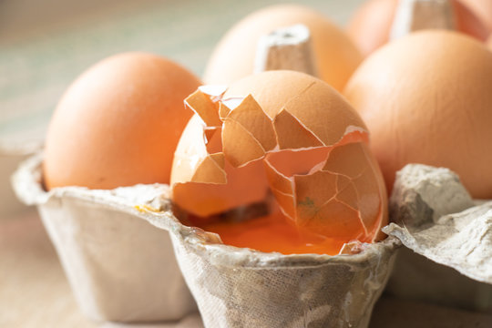 Yellow Broken Raw Egg In A Carton On The Table