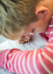 the boy is writing cursive close up