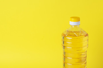 Plastic bottle with vegetable oil on a yellow background. Copy space.