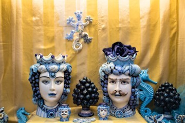 Dark brown heads and pinecones of blue ceramic of handmade production Sicilian to promote the Sicily region in Italy