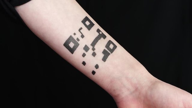 The girl rolls up her sleeve, showing a drawing, an abstract tattoo of a QR code on her arm. The concept of using, quick access to personal data, chipping.