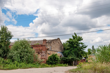 Fototapeta premium Old abandoned house. Village view of countryside in European country. Abandoned buildings overgrown by plants