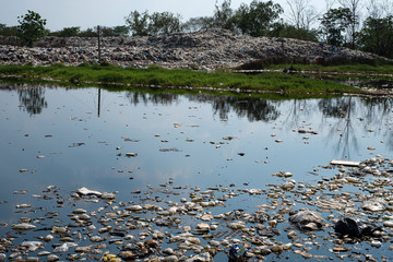 Polluted water and mountain large garbage pile and pollution, Pile of stink and toxic residue, These waste come from urban and industrial areas can not get rid of