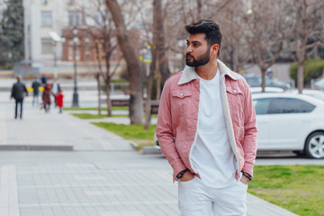 Bearded Indian man walks down the street.