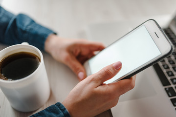 Girl working, learns, using laptop computer, cell phone, drink coffee on table. Freelance. Work home. Online education. Communication, technology concept. Top side view.