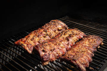 Grilled spareribs lying on the grillage of a smoker