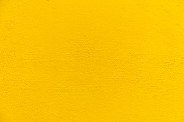 Blurred Yellow stucco wall background. Yellow painted cement wall texture.