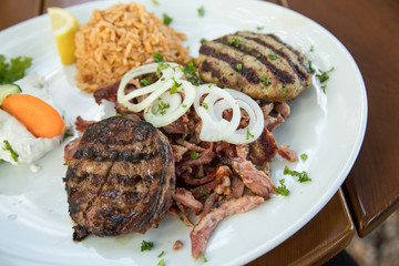 Griechischer Grillteller mit gegrillter Leber, Bifteki, Gyros, Zwiebeln, Tsatsiki, Krautsalat und...