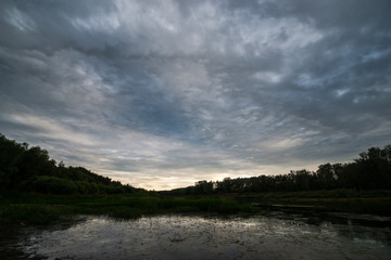 calm river-Ural flows in the sunset and stormy sky