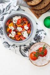 Healthy salad with grilled pepper, tomatoes, stracciatella, herbs and pumpkin seeds. Healthy eating concept.