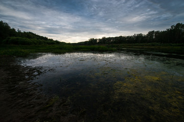 calm river-Ural flows in the sunset and stormy sky