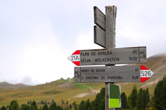 Mountain distance sign. Hiking trail in Italian Dolomites, Pian dei Menis with a view on majestic mountains, Italy.