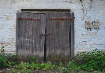 old closed wooden warehoese door in old brick building