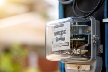 Electricity meters for home electrical appliances, including blurred natural green backgrounds,...
