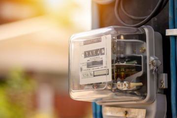 Electricity meters for home electrical appliances, including blurred natural green backgrounds,...