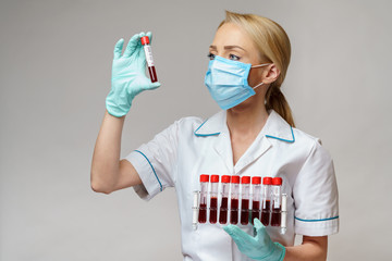 medical doctor nurse woman wearing protective mask and gloves - holding rack with virus blood tests