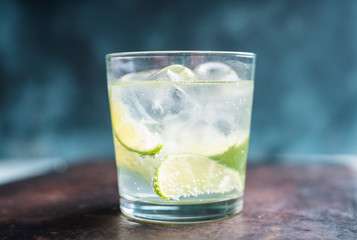 Rum based cocktail caipirinha (variation of cuba libre) on the rustic background. Selective focus. Shallow depth of field.