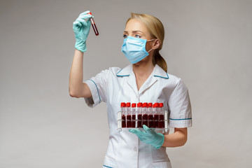 medical doctor nurse woman wearing protective mask and gloves - holding rack with virus blood tests